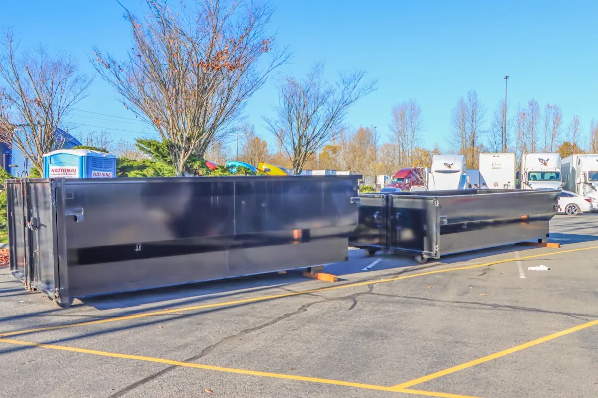 Professional dumpster rental service with roll-off container on residential driveway in East Buffalo